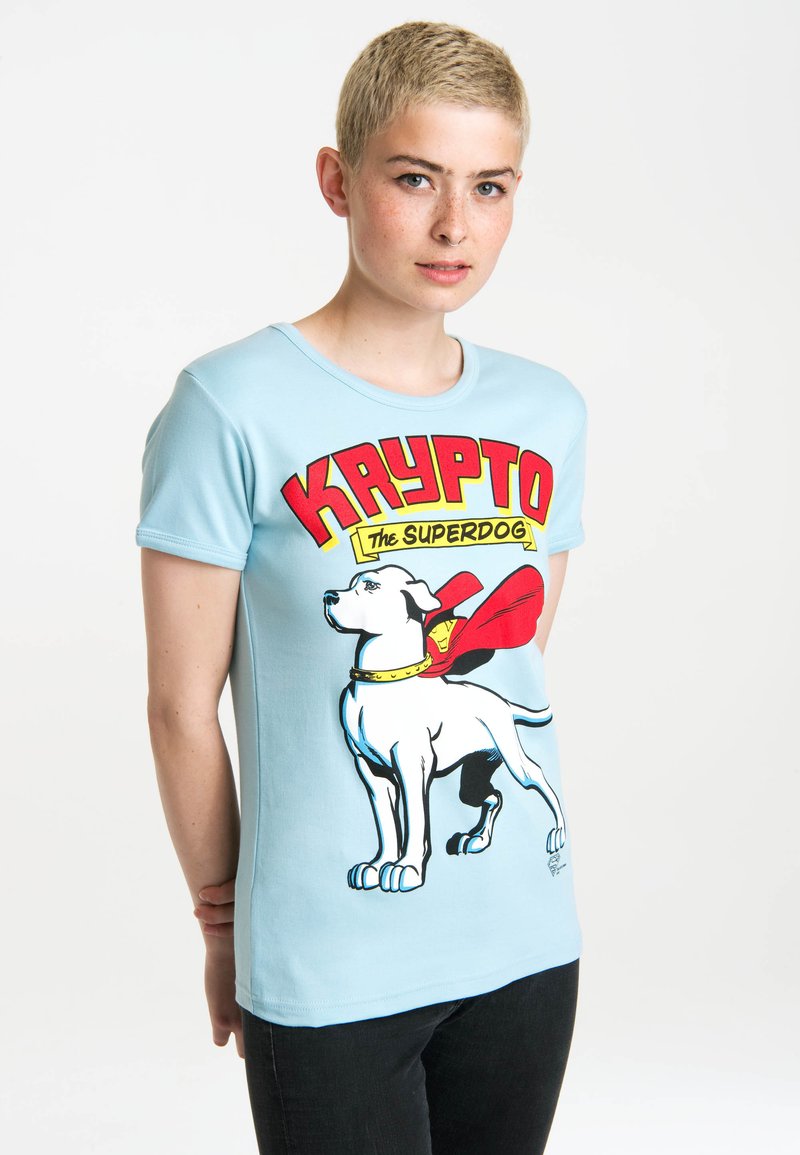 Light blue t-shirt featuring a graphic of a dog with a red cape. Soft material, short sleeves, round neck, and fitted design.