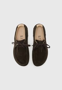 Brown suede shoes with a round toe, contrasting stitching, and lace-up design. Soft texture, no visible hardware, plain inner lining.