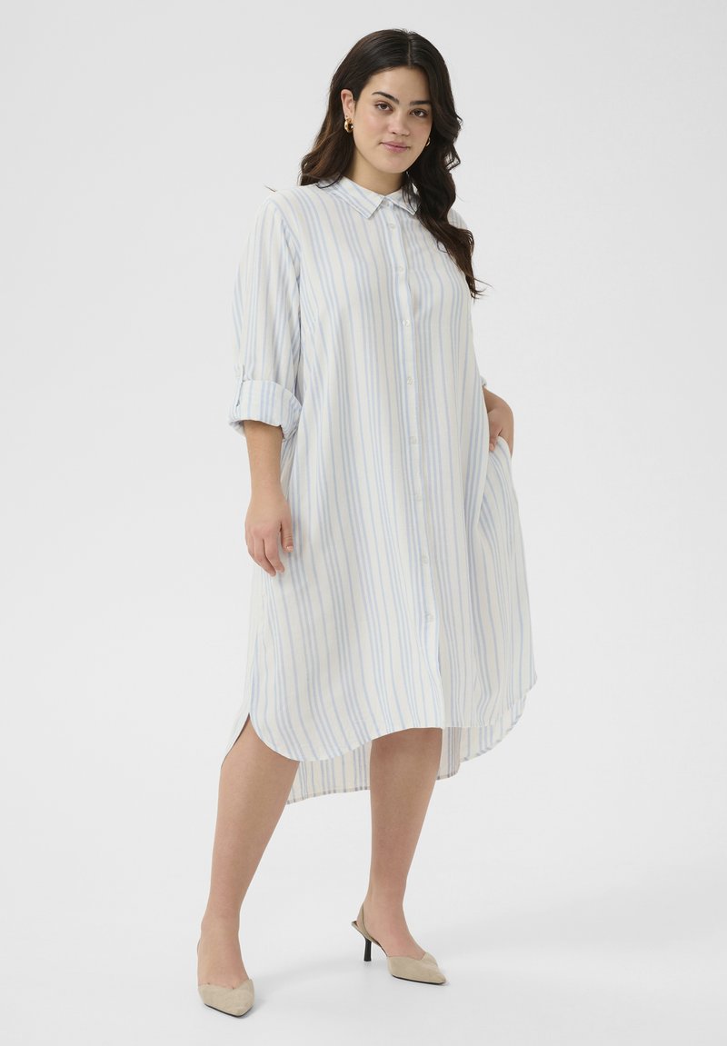 Robe chemise boutonnée en tissu léger, avec des rayures verticales bleues et blanches, des manches longues et un ourlet asymétrique.