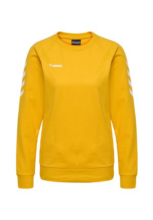 Żółta bluza z długim rękawem, z ribbowymi wykończeniami rękawów i dołu, z białym logo i wzorami w kształcie chevron na rękawach. Gładka tekstura.