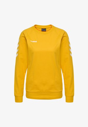Gul sweatshirt med lange ærmer, ribbede manchetter og kant, med hvidt logo og chevronmønstre på ærmerne. Glat tekstur.