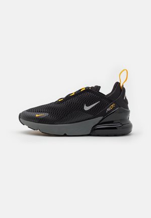 Basket Nike Air Max 270 noire et grise avec des touches jaunes, tige en mesh et semelle à coussin d'air visible sur fond blanc.