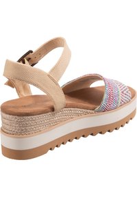 Strappy beige platform sandals with multi-colored geometric patterned fabric, textured jute midsole, and white rubber outsole with grooves.