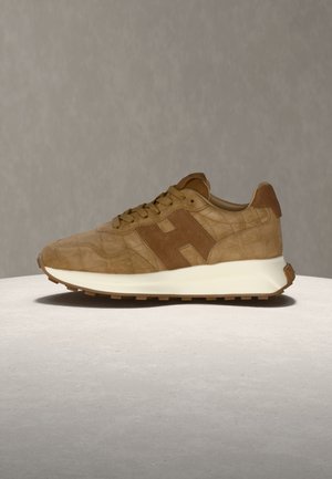 Brown suede sneaker with textured pattern, tonal laces, padded collar, and white cushioned sole on light gray surface and background.