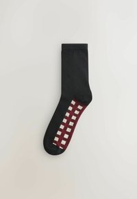 Čierna ponožka s marónovo-bielym kockovaným vzorom po stranách, s hladkou textúrou a štandardnou dĺžkou ponožky.
