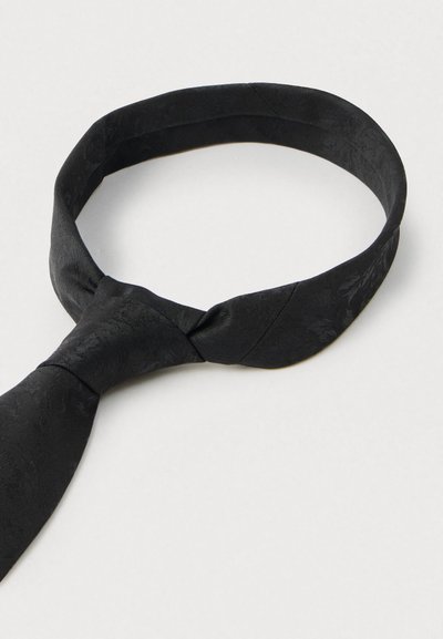 Melnā tauriņš no teksturētas auduma ar smalku rakstu. Cilpas formā ar mezglotu daļu, paredzēts oficiāliem pasākumiem.