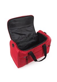Bolsa de deporte de tela roja con cierre de cremallera, interior negro, dos asas superiores y bolsillo exterior con cremallera. Abierta y vacía.