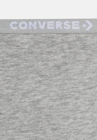 Γκρι βαμβακερό ύφασμα με υφή heathered. Διαθέτει λευκή ελαστική ζώνη με την επιγραφή "CONVERSE" από π�άνω. Απλός, καθαρός σχεδιασμός.
