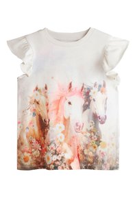 Haut blanc sans manches pour enfants avec emmanchures volantées, représentant trois chevaux ornés de couronnes florales et entourés de fleurs.