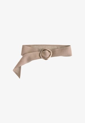 Beige stofbælte med en rund metal spænde, delvist foldet med den ene ende hængende ned.