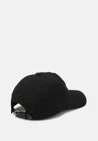 Μαύρο καπέλο μπέιζμπολ με καμπυλωτό γείσο, φτιαγμένο από βαμβάκι. Διαθέτει μια υφασμάτινη θηλιά με μεταλλική πόρπη για προσαρμογή στο πίσω μέρος.