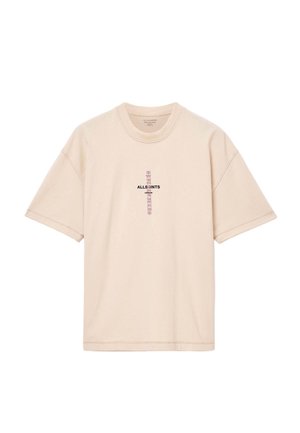 Beżowa bawełniana koszulka T-shirt z krótkim rękawem, okrągłym dekoltem i logo na przodzie. Charakteryzuje się luźnym krojem i widocznymi szwami.