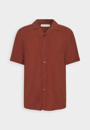 Camisa de botão de manga curta, na cor ferrugem, feita de um tecido suave. Apresenta um colarinho pontudo e cinco botões na frente.
