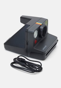 Polaroid camera in matte black with a compact design. Features a rainbow stripe, lens, dual flash, and included charging cable.
