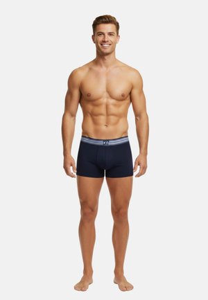 Marineblå boxer briefs med en grå elastisk talje, der har "CR7"-logoet. Glat tekstur, tætsiddende design, længde til midt på låret.