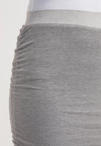 Jupe grise texturée avec un design froncé. Tissu doux et extensible doté d'une large ceinture, offrant un ajustement confortable.