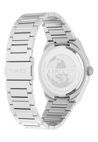 Montre en acier inoxydable argenté avec un boîtier hexagonal, un bracelet brossé et un fond transparent présentant un design de globe.