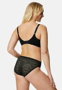Set di lingerie in pizzo nero, composto da un reggiseno testurizzato con spalline regolabili e slip coordinati con motivo in pizzo floreale.