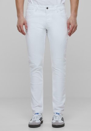 White slim-fit jeans featuring a smooth, textured fabric with distressed details, finished with a front button closure and five-pocket design.