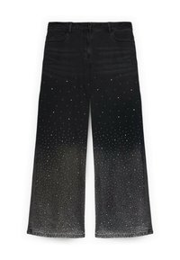 Mustat farkut, joissa on leveät lahkeet ja joissa on kimalteita, jotka vaihtelevat tiheydestä harvempaan kohti lahkeiden huippua.