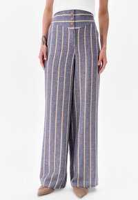 Brede broek in blauw met gele verticale strepen. Heeft een hoge tailleband met drie houten knopen. Glad textuur en op maat gemaakt pasvorm.