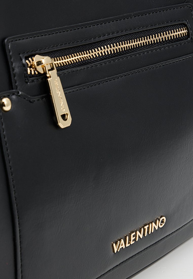 Borsa Valentino in pelle nera con zip dorata e logo, in primo piano con dettagli della tasca frontale e della zip.