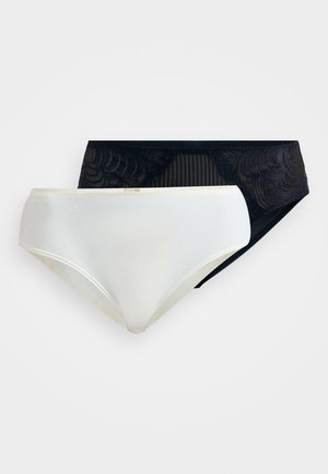 To kvinnelig bikiniundertøy, en ensfarget hvit og en svart med blonder og meshdetaljer, på en hvit bakgrunn.