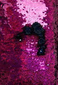 Tessuto in paillettes con dischi rotondi sovrapposti di colore rosa, viola e nero, creando una superficie testurizzata con un aspetto luccicante.