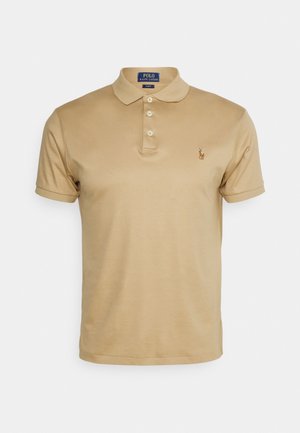 Polo beige Ralph Lauren ajusté à manches courtes, avec trois boutons et logo brodé sur le côté gauche de la poitrine.