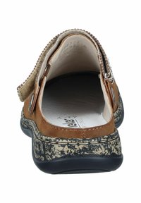 Braune Wildleder-Slipper mit einer strukturierten schwarz-weißen Sohle; ausgestattet mit einer abgerundeten Zehenpartie und einem verzierten Riemen mit dekorativen Nähten.
