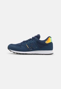 Navy blue athletic sneaker with mesh and synthetic upper, white midsole, black outsole, iridescent heel tab, and lace-up closure.