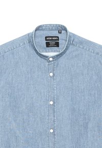 Camicia in denim azzurro chiaro con colletto a banda, cinque bottoni bianchi e una texture sottile. L'etichetta recita "ANTONY MORATO, TOLEDO, REGULAR FIT."