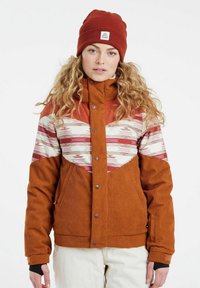 Oranje corduroy jas met een met patroon bedekt stof in roze, wit en wijnrode accenten. Beschikt over een hoge kraag, drukknopen en zijzakken.
