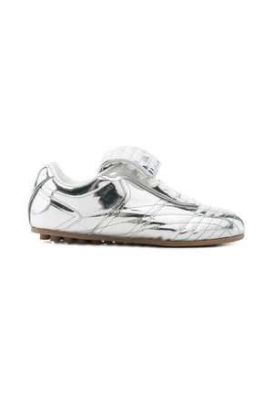 Sneaker basso metallizzato argento con una fascia in velcro, lacci bianchi, motivi cuciti e suola in gomma marrone.