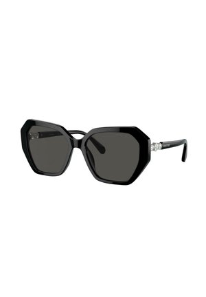 Occhiali da sole esagonali neri oversize con lenti scure e accenti in cristallo sulle aste nere.
