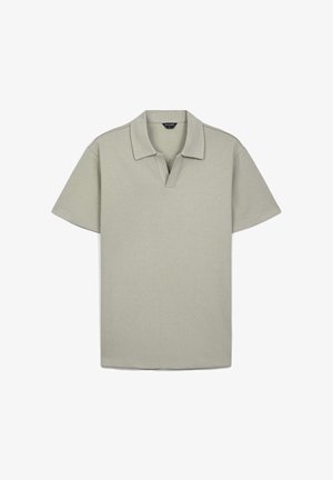 Helles grünes Polohemd mit kurzen Ärmeln, strukturiertem Stoff, Kragen mit partiellem Knopfverschluss, geradem Saum und ohne sichtbare Logos oder Muster.
