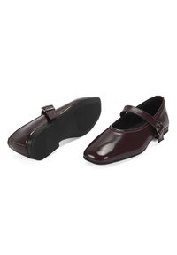 Bordeauxfarbene Lederschuhe mit quadratischer Zehenform, ausgestattet mit einem Schnallenriemen und einer strukturierten schwarzen Gummisohle für Grip und Stabilität.