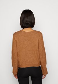 Brun, texturerad stickad tröja med långa ärmar och rund halsringning, med en kortad passform och ribbad nederkant.