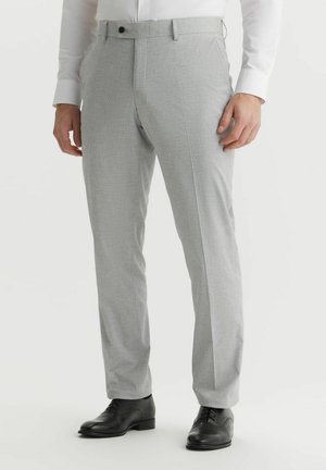 Szare wzorzyste spodnie o dopasowanym kroju, z prostym przodem, bocznymi kieszeniami i eleganckim pasem, zestawione z czarnymi butami wizytowymi.