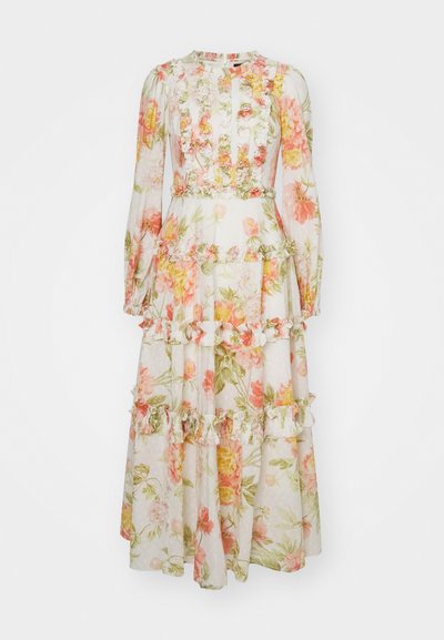 Robe maxi en tissu léger et translucide avec un imprimé floral rose et vert, ornée de volants et de manches longues. Se prolonge jusqu'à la cheville.