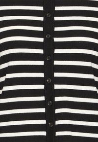 Cardigan rayé horizontal noir et blanc boutonné avec six boutons noirs au centre devant.