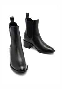 Czarne skórzane botki za kostkę z teksturowanym wykończeniem, elastycznymi bocznymi panelami i niskim, blokowym obcasem. Projekt w szpic z pętelką z tyłu.