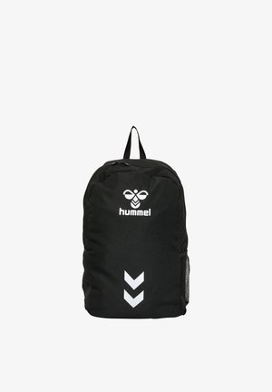 Zaino nero Hummel con logo bianco e due frecce bianche rivolte verso il basso, cerniera nera e tasca laterale in rete su sfondo bianco.