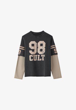 Camicia a maniche lunghe nera e beige con la scritta "98 CULT" stampata sul davanti e sulle maniche, caratterizzata da un design a maniche sovrapposte.