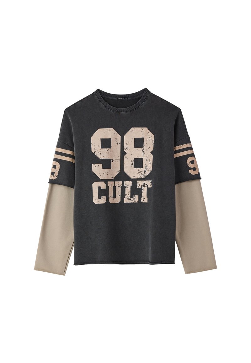 Camicia a maniche lunghe nera e beige con la scritta "98 CULT" stampata sul davanti e sulle maniche, caratterizzata da un design a maniche sovrapposte.