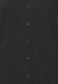 Zwarte button-up shirt van gladde stof met een rechte snit, voorzien van een rij van zes zwarte knopen aan de voorkant.