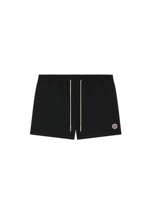 Shorts de bain noirs avec des cordons blancs et un petit logo circulaire sur la partie inférieure de la jambe gauche.