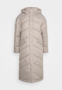 Long beige puffer coat featuring a hood, diagonal quilted pattern, two side pockets, and a straight hem. Lightweight, textured fabric.