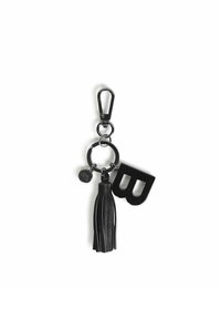 Portachiavi nero con un pom pom, anello circolare e una grande lettera "B" con una finitura lucida. Realizzato con componenti in pelle e metallo.