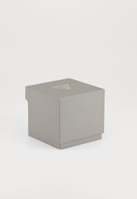 Boîte en papier gris avec une finition texturée, de forme carrée, et un logo doré sur le dessus. Design fermé avec un couvercle à rabat pour un accès facile.